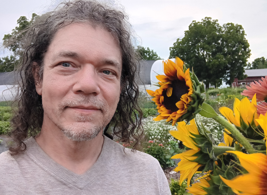 Paul with sunflowers in the field